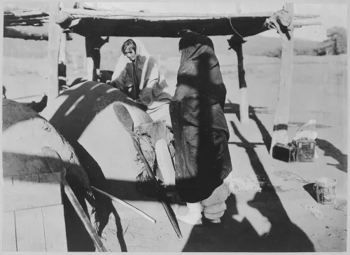 Two Taos women baking bread in outside oven, New Mexico #70