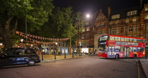 Night photograph of Sloane Square with double decker bus #16